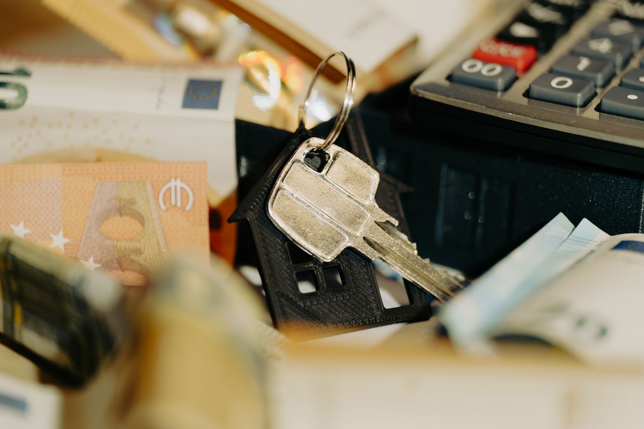 services-01 House keys rest on a keychain with euro banknotes and calculator, symbolizing real estate investment.