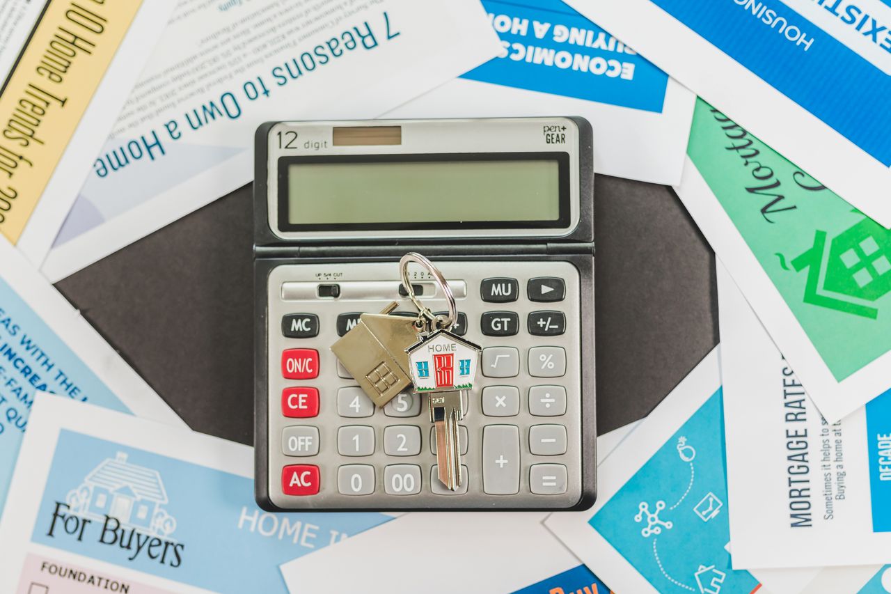 about-01 Calculator with keys and real estate documents symbolizes home buying finances.